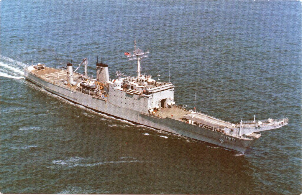 Postcard photo of USS Boulder underway, with visible rust along the hull
